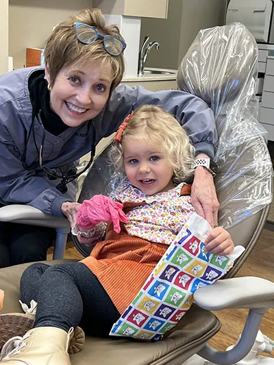Jan from the office of Robert M. Kelso DDS with pediatric patient smiling for camera