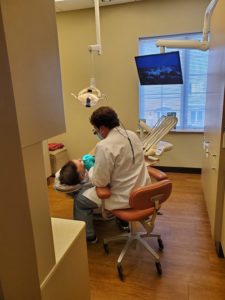 dentist cleaning patient's teeth